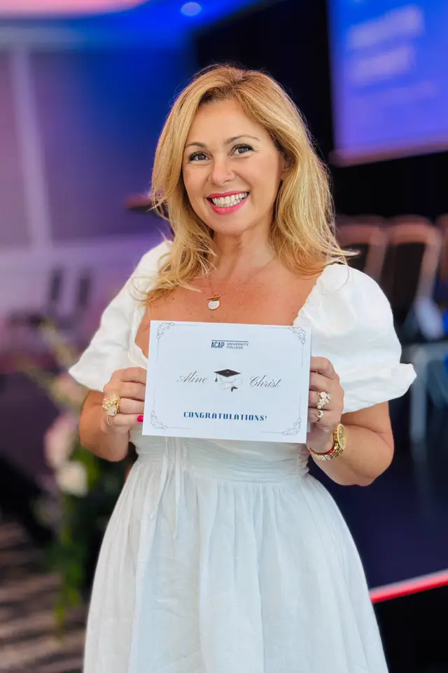 The photo Aline sent: holding a certificate at an event